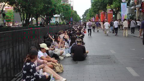 Người trẻ ngồi bệt ngoài đường, ăn vội bữa tối chờ đón countdown