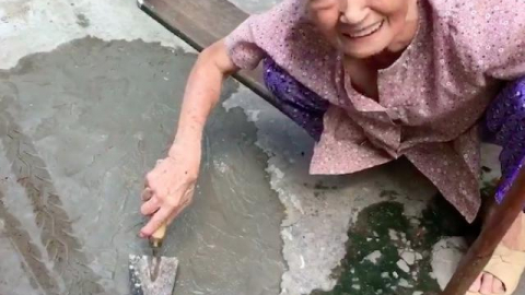 Xôn xao clip cụ bà ngoài 80 tuổi tự trộn xi-măng “vá” đường ở TP.HCM