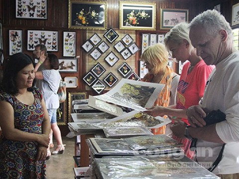 Chị Nguyệt Ánh tại cơ sở tranh bướm của mình với các vị khách Tây. Chị Nguyệt Ánh tại cơ sở tranh bướm của mình với các vị khách Tây.