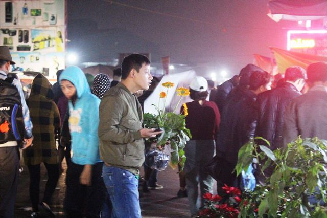 Một nam thanh niên mua được một cây hoa vui mừng vì đã thoát khỏi đám đông. Một nam thanh niên mua được một cây hoa vui mừng vì đã thoát khỏi đám đông.