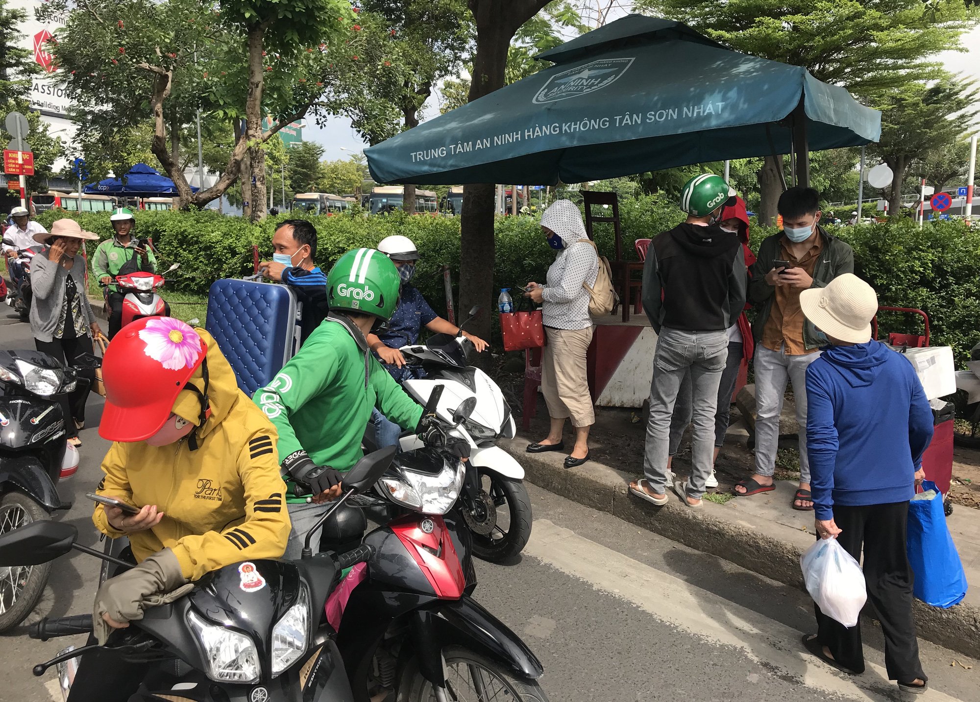 Khách vã mồ hôi, vác vali ra khỏi sân bay Tân Sơn Nhất,  cắt ngang làn ô tô để đón xe - Ảnh 5.