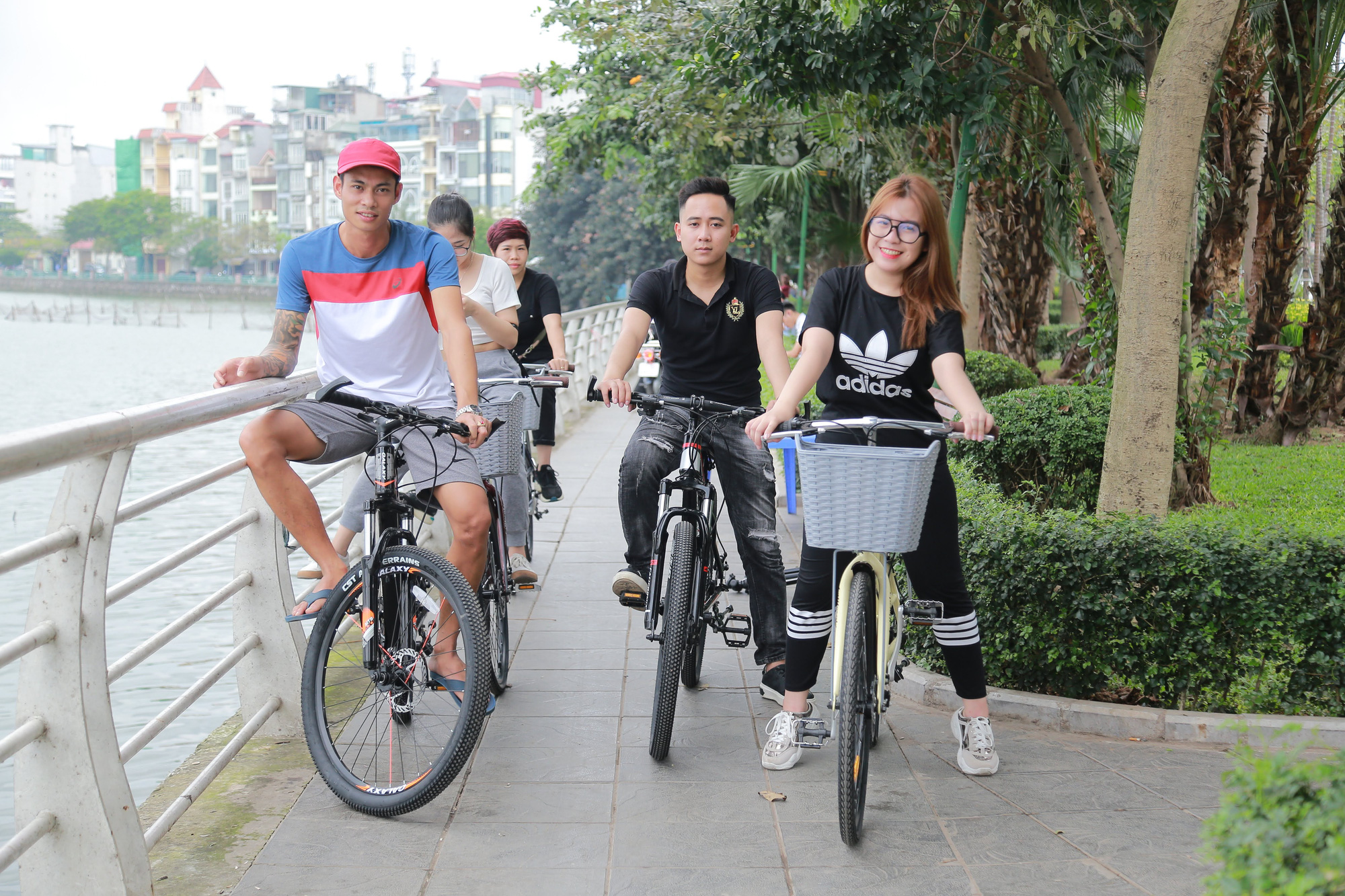 Anh Xuân Lĩnh (bên trái) tuần nào cũng thuê xe đạp xe cùng vợ và câu lạc bộ xe đạp Hồ Tây. Ảnh: N.T