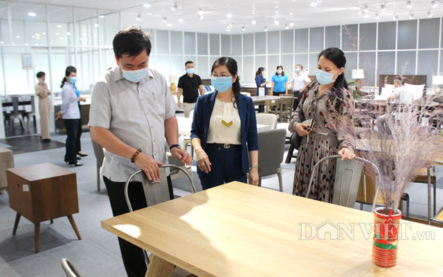 Bà Lê Thị Xuyến (giữa) giới thiệu sản phẩm gỗ nội thất cho khách hàng đến tham quan trực tiếp tại showroom