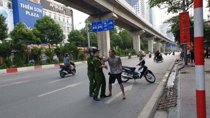 Cận cảnh khống chế kẻ nghi ngáo đá dọa giết người đi đường, đánh công an, chặn ô tô trấn tiền - Ảnh 2.