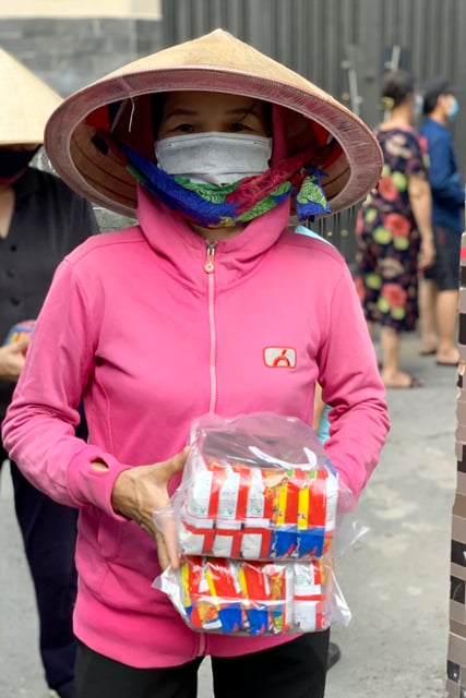 Người nghèo nhận phần quà gồm mì gói và khẩu trang