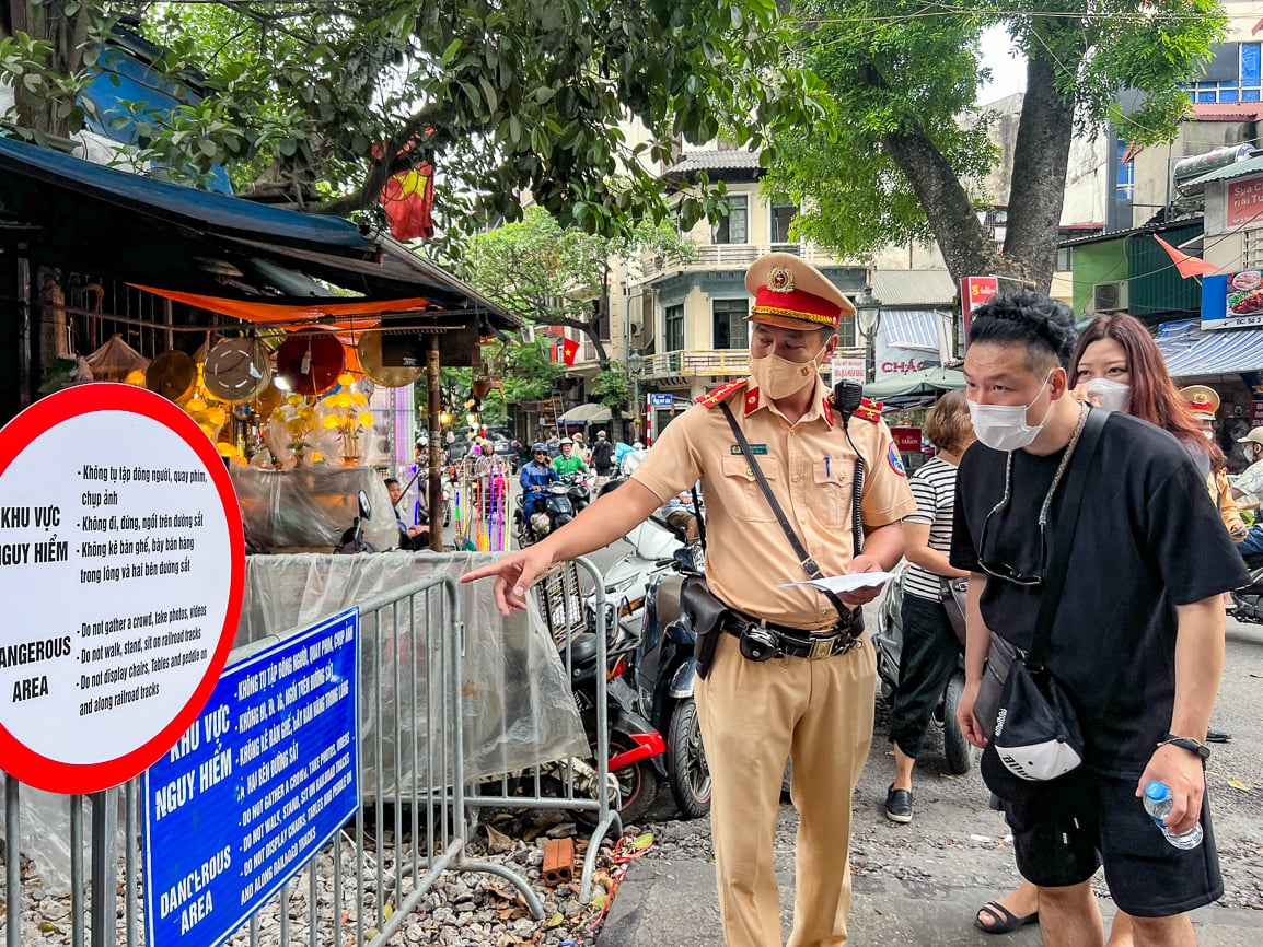 Phát tờ rơi song ngữ tuyên truyền an toàn đường sắt tại phố cà phê đường tàu - Ảnh 2.