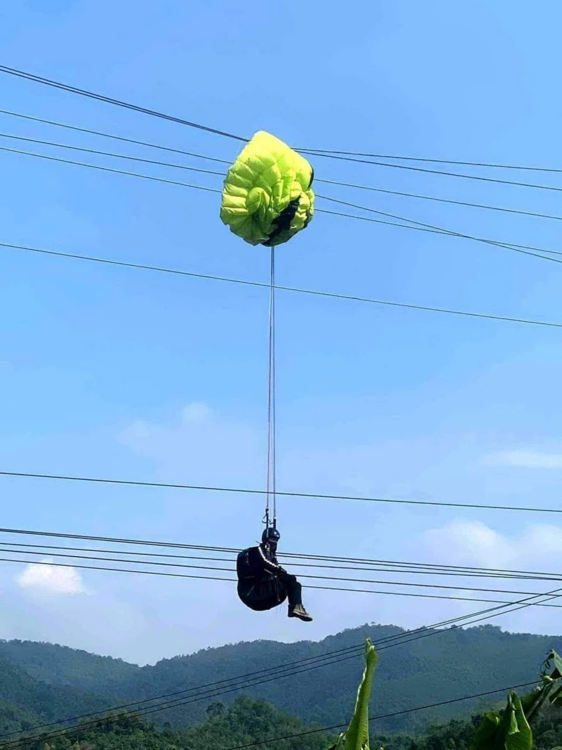 Vướng vào đường dây điện 35kV, vận động viên nhảy dù treo lơ lửng nhiều giờ liền trên không- Ảnh 1.