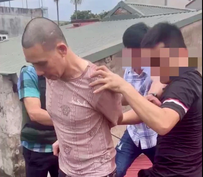 Đối tượng trốn truy nã 18 năm leo lên mái nhà khi bị cảnh sát vây bắt- Ảnh 1.