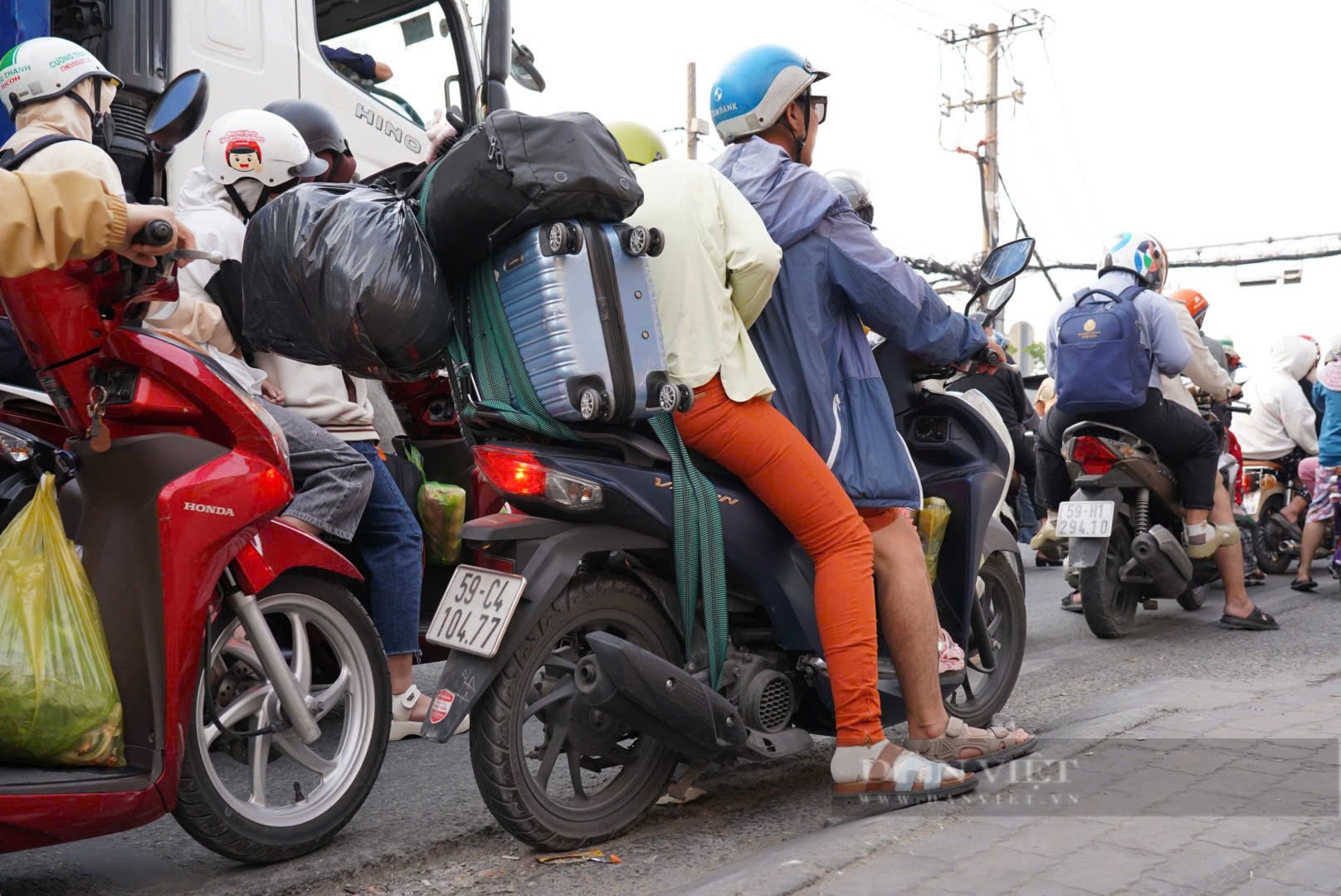 Trẻ em ngủ gục trên xe máy theo cha mẹ trở lại TP.HCM sau kỳ nghỉ Tết - Ảnh 6.