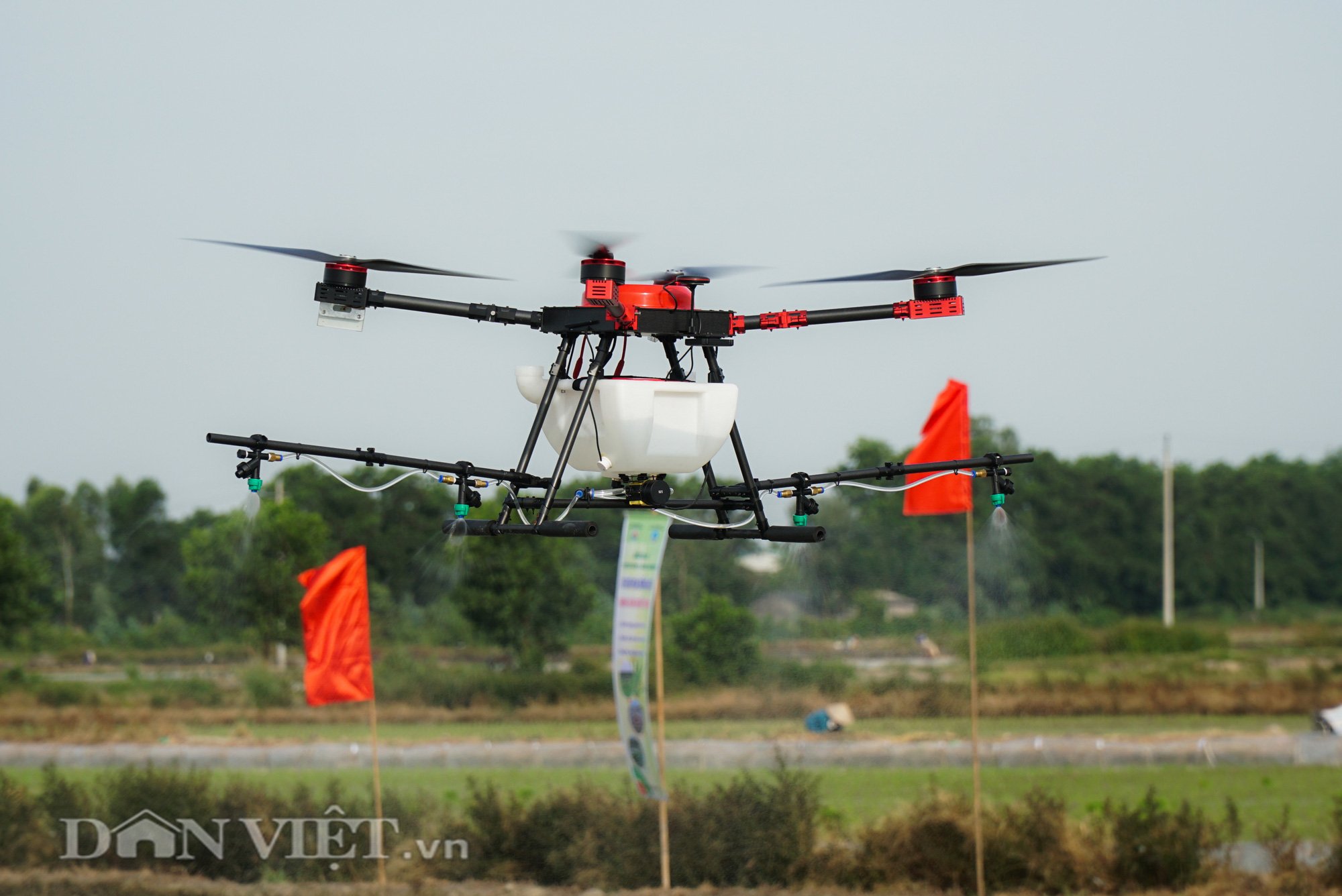 Tận mắt chứng kiến máy bay không người lái phun thuốc trên đồng ruộng - Ảnh 2.