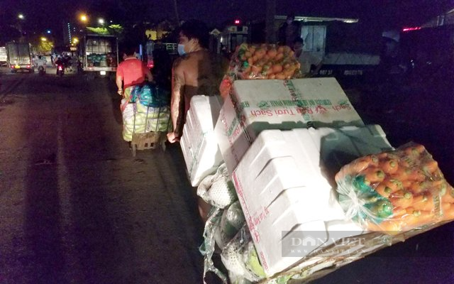 Rau củ được vận chuyển ra bên ngoài chợ, nơi có khách hàng đợi sẵn. (Ảnh: Nguyên Vỹ)