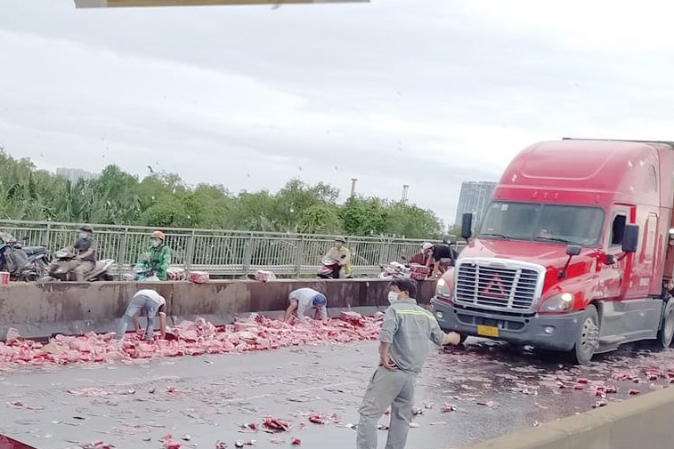 Hàng trăm lon nước ngọt rơi vãi trên cầu Phú Mỹ do tai nạn, nhiều người dừng xe đi vào làn ô tô “hôi của” - Ảnh 1.
