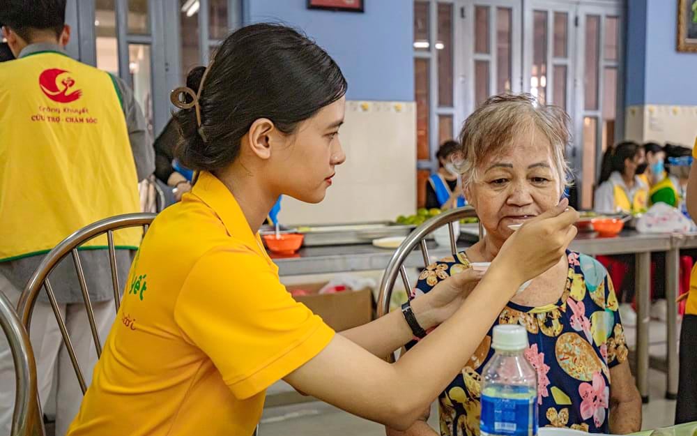 Tình nguyện viên Quỹ Trăng Khuyết chăm sóc người già neo đơn. Ảnh: NVCC