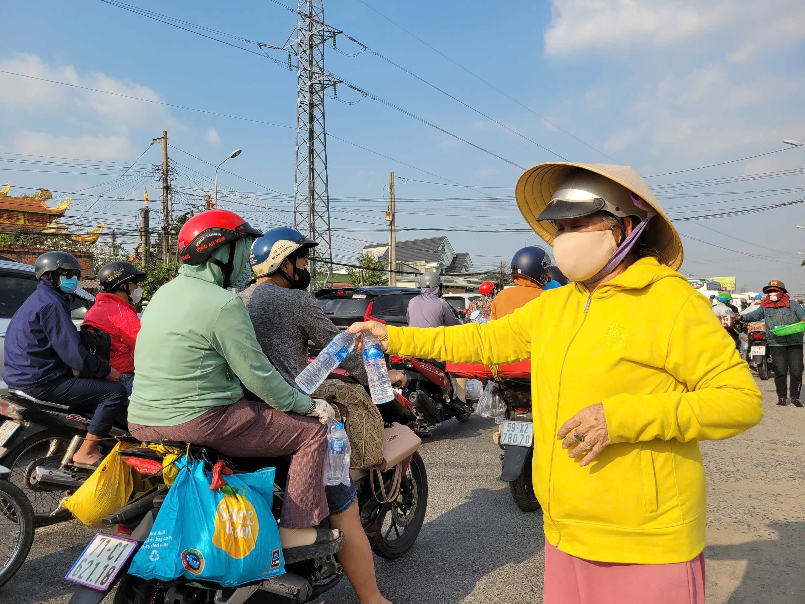 Cán bộ xã ở Long An phát gần 20.000 chai nước suối, bánh mì, khăn lạnh miễn phí cho dân miền tây về TPHCM  - Ảnh 2.
